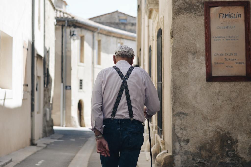 A man wearing braces (UK word) suspenders (American word) walks away from the camera with his back to us.